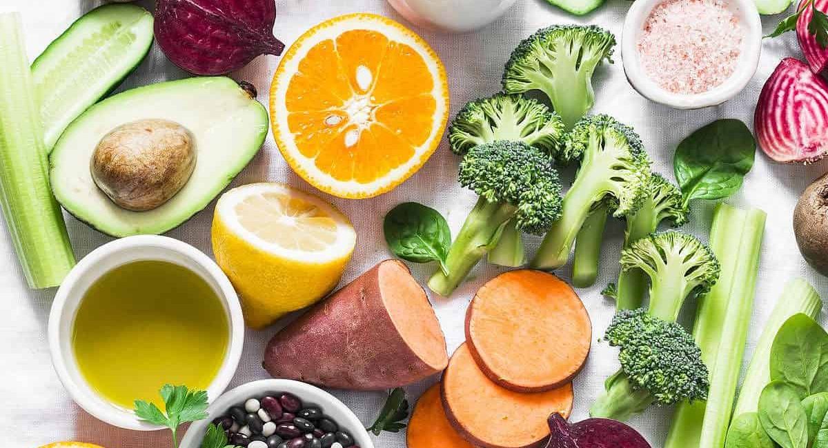 Five best vitamins for beautiful skin. Products with vitamins A, B, C, E, K - broccoli, sweet potatoes, orange, avocado, spinach, peppers, olive oil, dairy, beets, cucumber, beens. Flat lay, top view